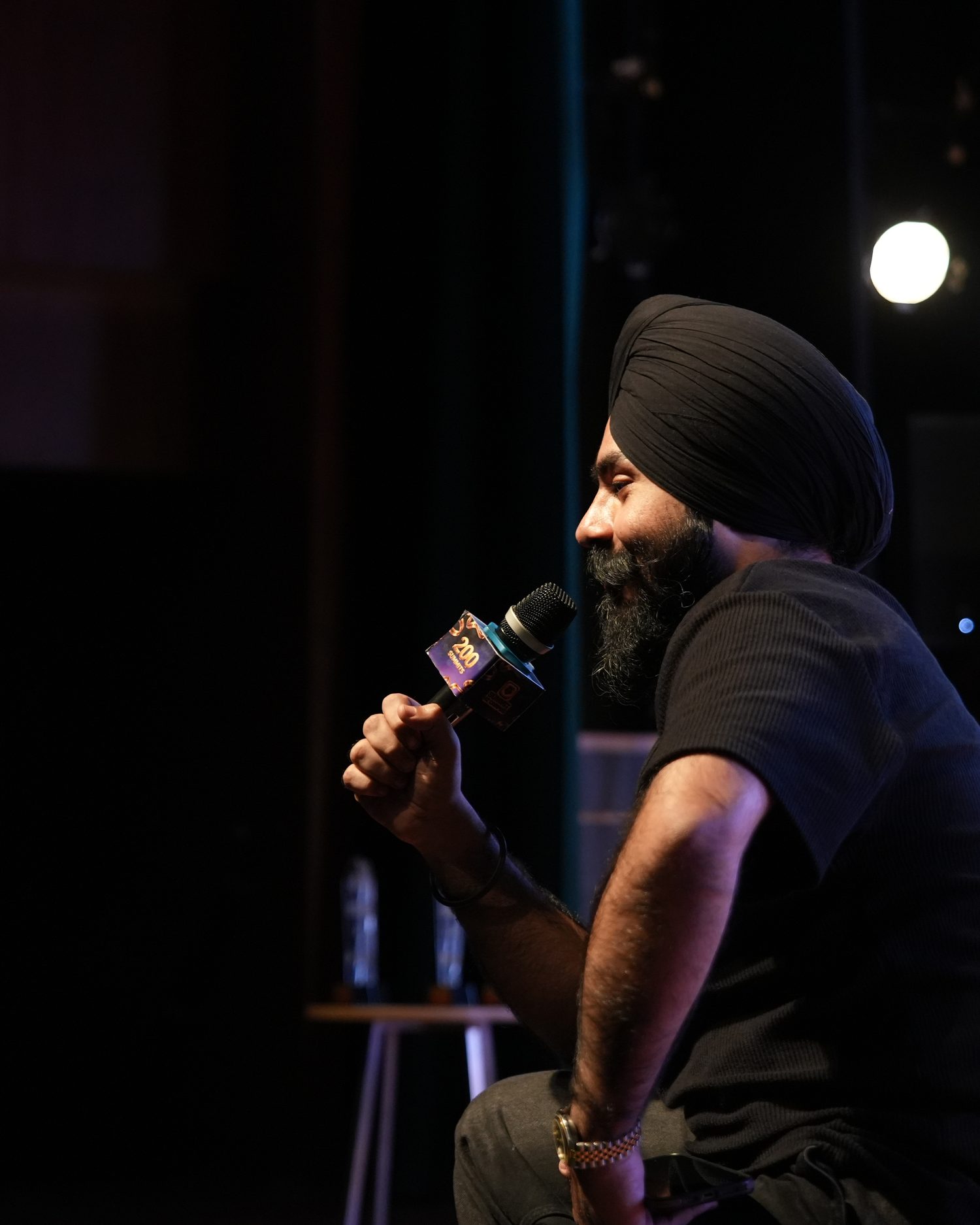 Harman on a big stage with a microphone